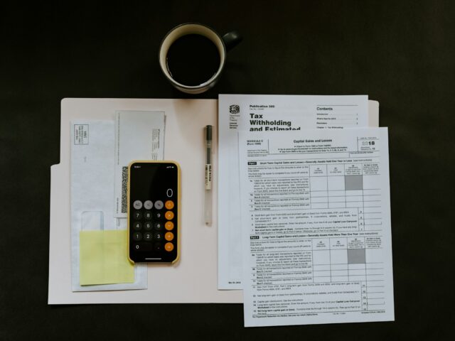 Formulare, Taschenrechner und Kaffeetasse auf einem Tisch
